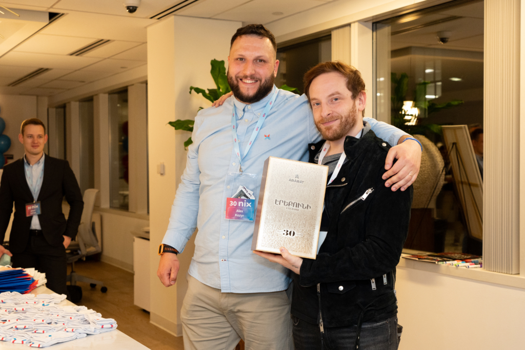 Men Posing With Gift At NIX 30th Anniversary